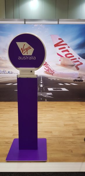 purple virgin branded photo booth set up in front of a virgin media wall showing a plan and runway